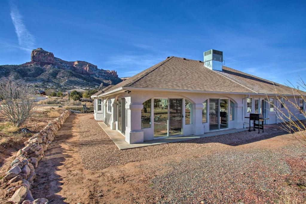 a small white house with a mountain in the background at Grand Junction Retreat Near National Monument! in Grand Junction