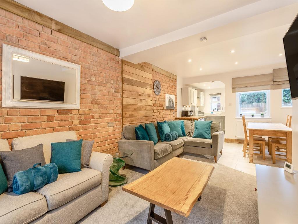 a living room with two couches and a brick wall at Kings Retreat in Oakham