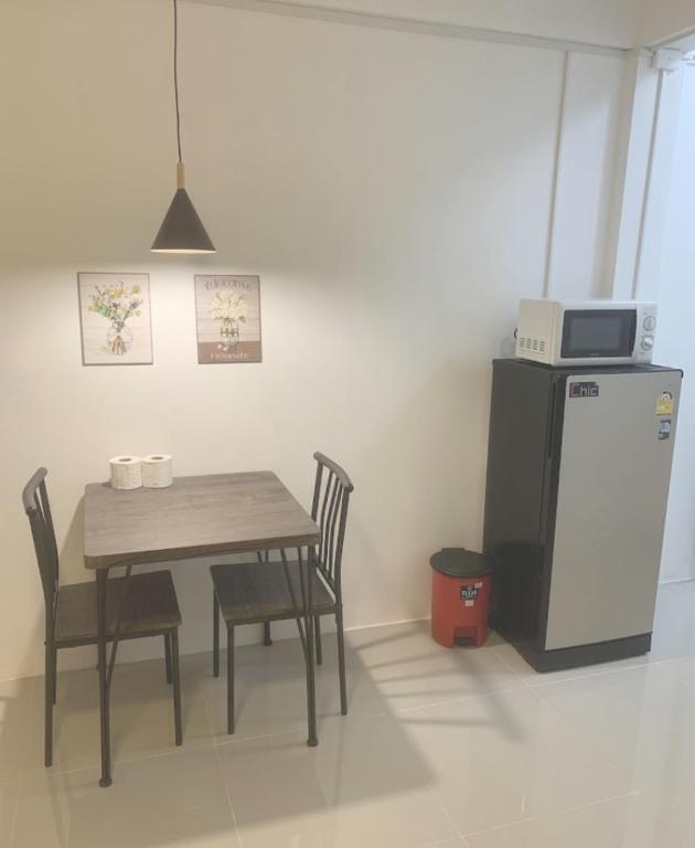 a dining room with a table and a refrigerator at Barzilla Bar And Guesthouse in Pattaya