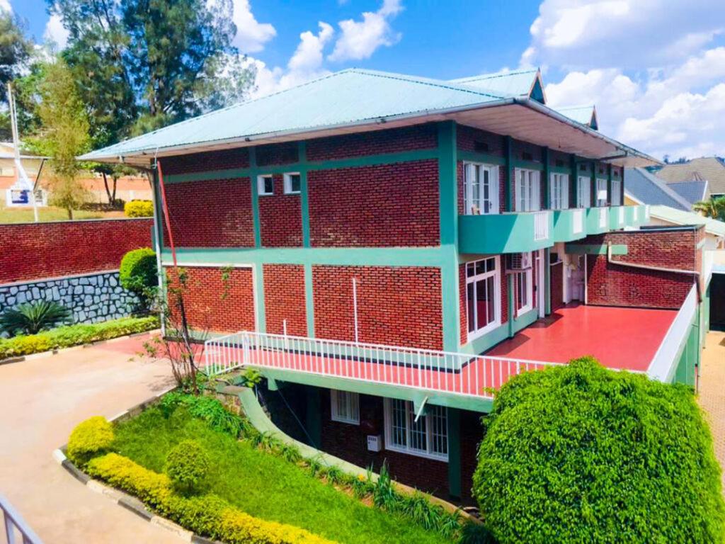 un edificio de ladrillo rojo con techo rojo en MOUCECORE en Kigali