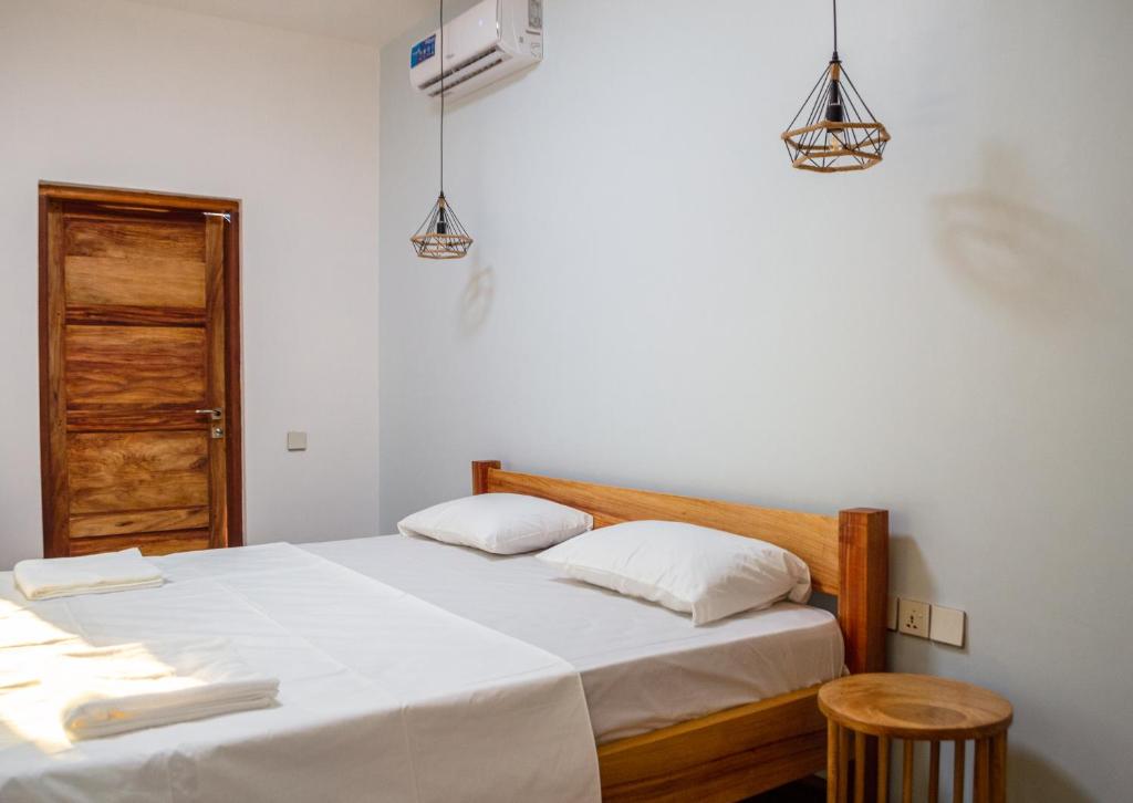 a bedroom with a bed with two white pillows at Nebo Apartments Paje in Paje