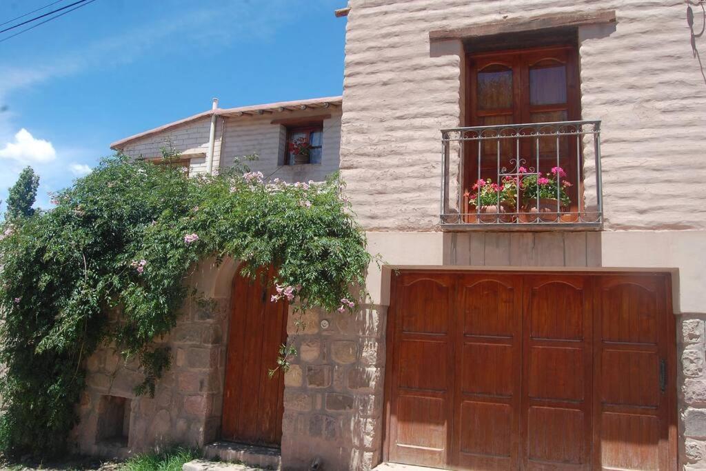 a house with a wooden garage door and a window at El Ensueño in Tilcara
