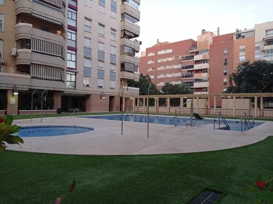 a swimming pool in a city with tall buildings at 2 rooms con piscina litoral in Málaga