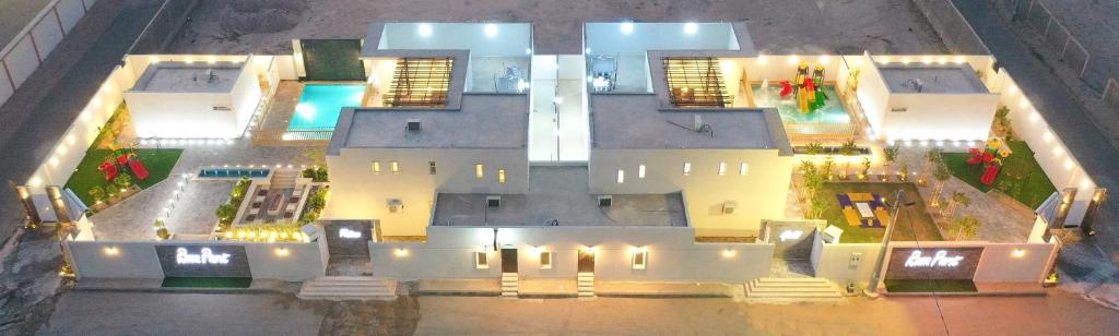 eine Luftansicht eines großen weißen Hauses mit Lichtern in der Unterkunft منتجعات روزا بارك in Ad-Dawādimi