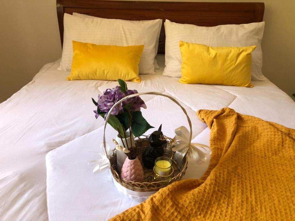 a basket with flowers and candles on a bed at Two bedroom Apartment in Oyster Bay in Dar es Salaam