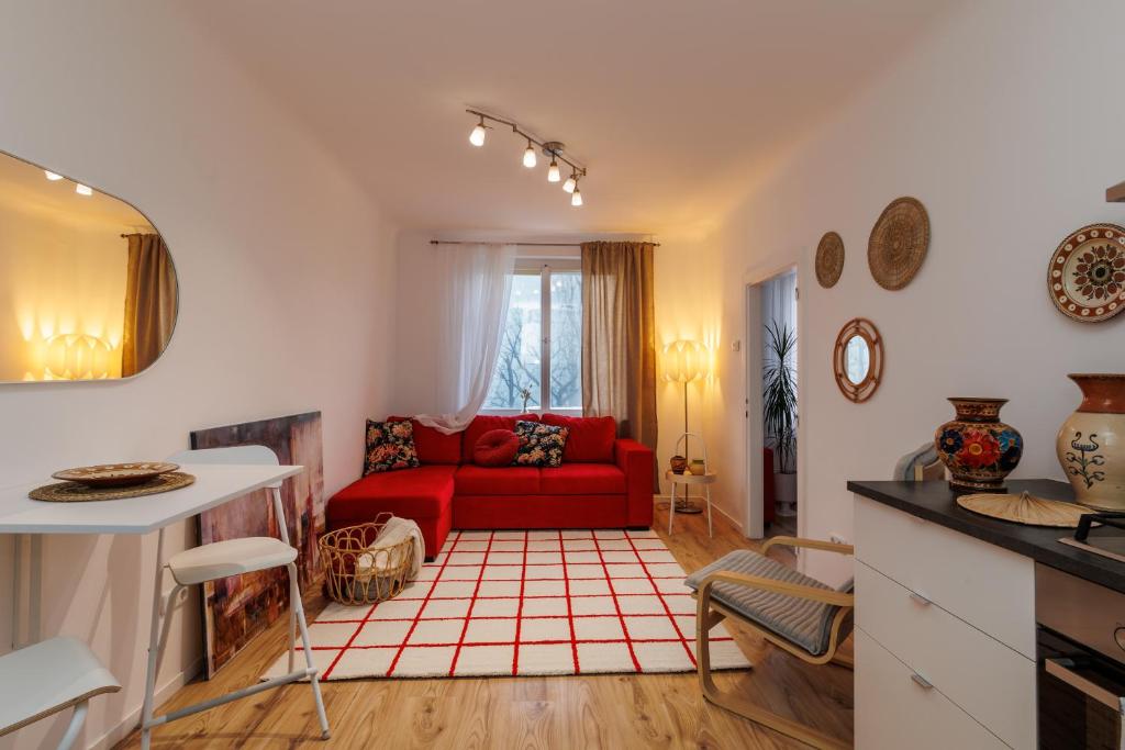 sala de estar con sofá rojo y mesa en Cosy brand new Apartment, en Viena