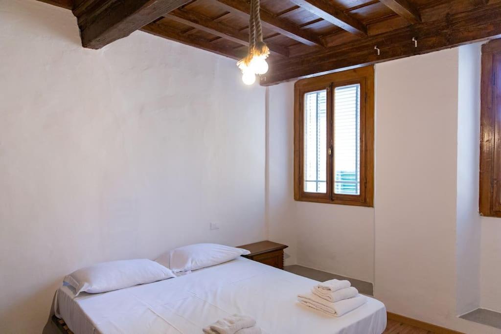 ein Schlafzimmer mit einem weißen Bett und einem Fenster in der Unterkunft Sweet Apartment Near Piazza Pitti in Florenz