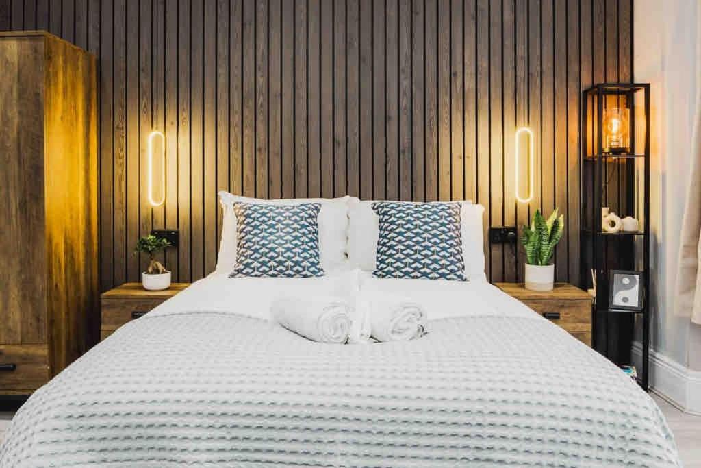 een slaapkamer met een groot bed met blauwe en witte kussens bij Modern 2 bed flat near Wembley Stadium in Londen