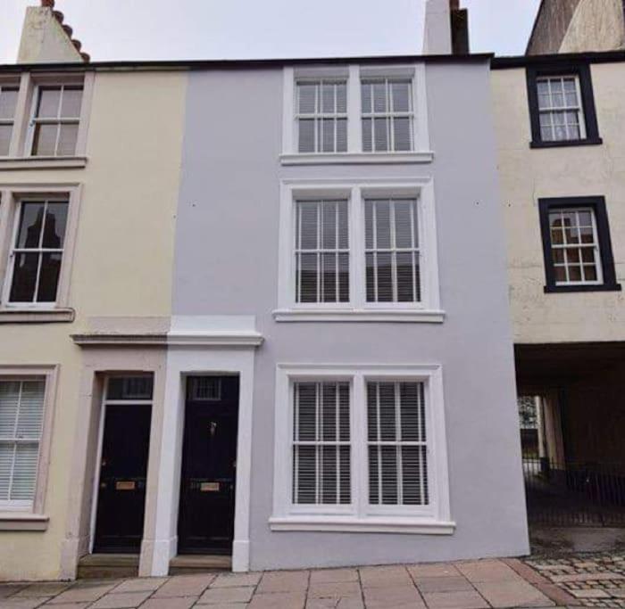 a white house with black doors and windows at Bounty Town House Cumbria in Whitehaven