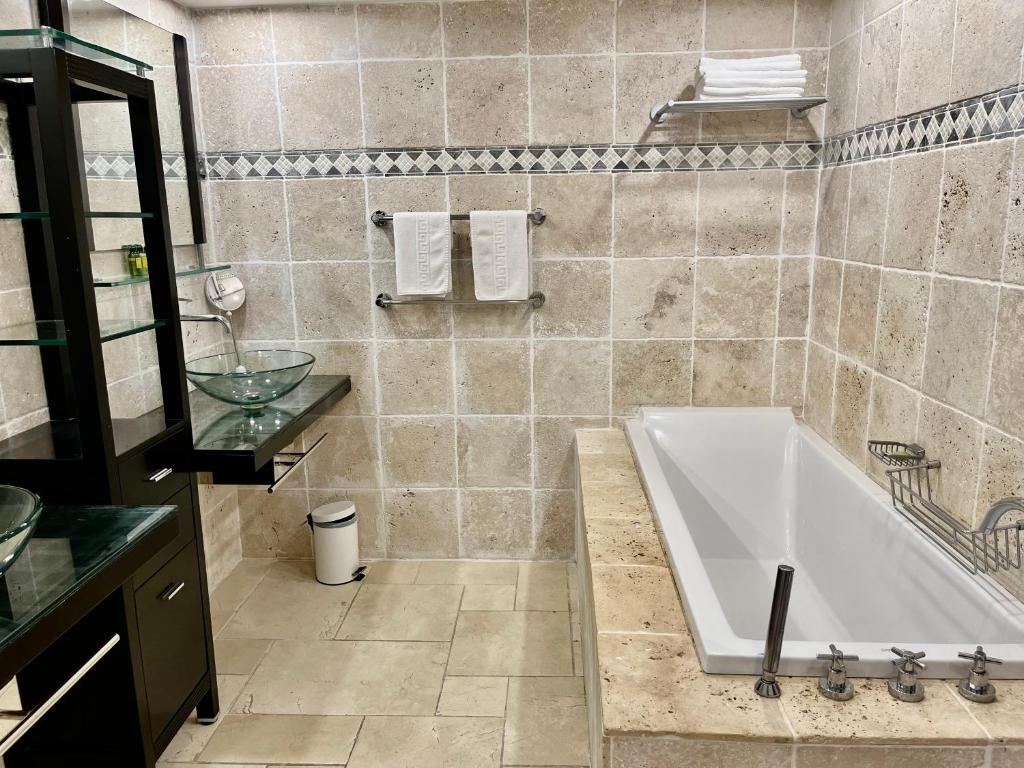 a bathroom with a tub and a sink at Le Domaine Anse Marcel Beach Resort in Anse Marcel 