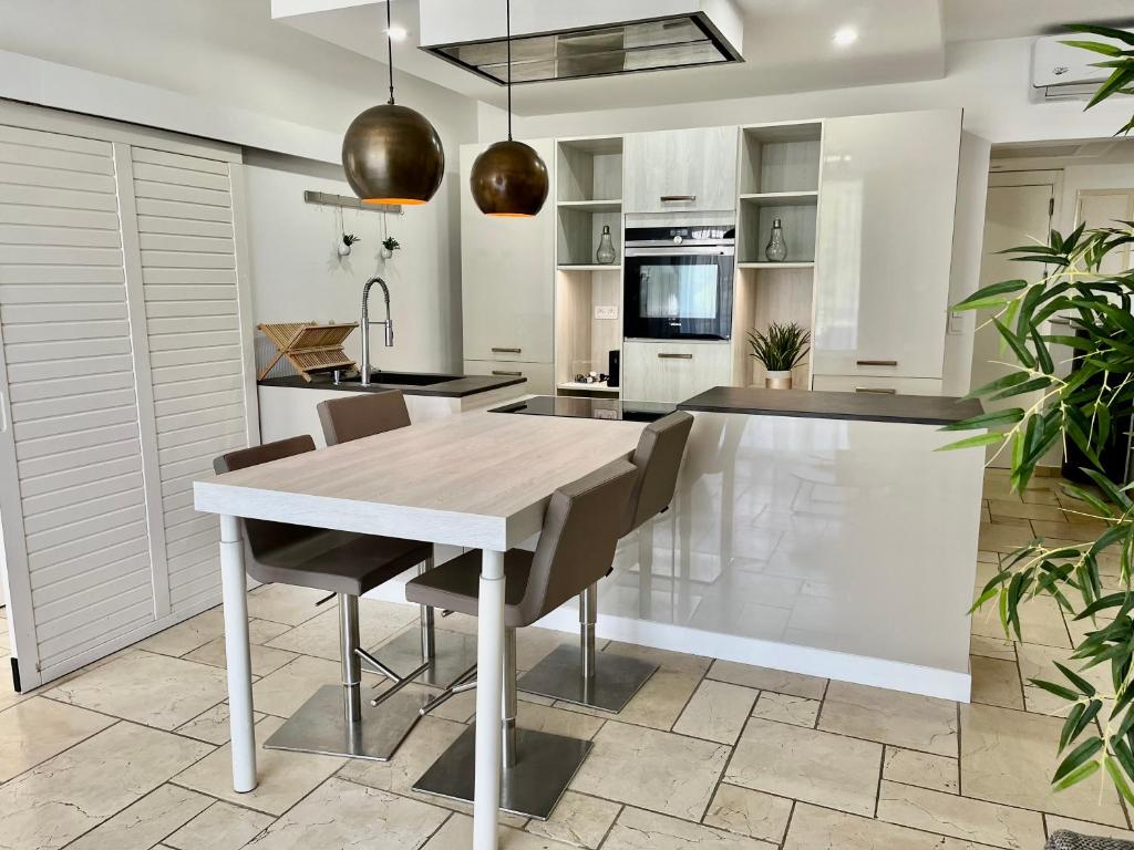 a kitchen with a wooden table and chairs at Le Domaine Anse Marcel Beach Resort in Anse Marcel 