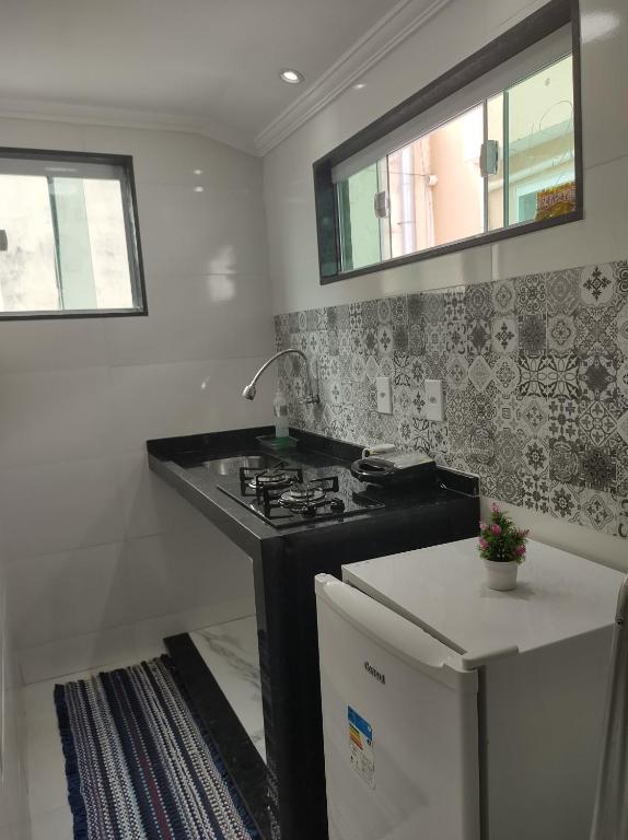 a kitchen with a sink and a stove at Loft Belas Praias in Arraial do Cabo