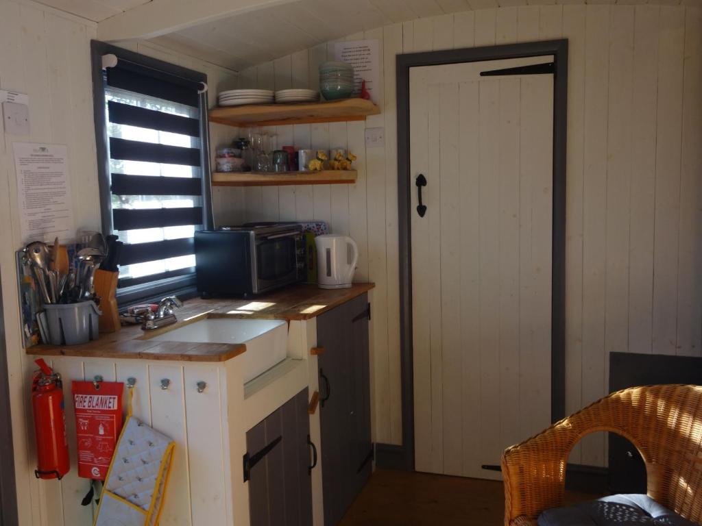 a small kitchen with a sink and a window at Shepherds Hut, Ryans Retreat, Bowness-on-Solway in Bowness-on-Solway