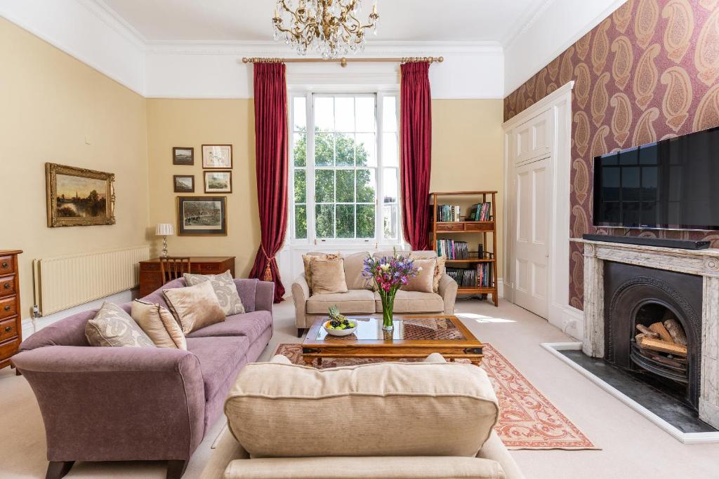 a living room with two couches and a fireplace at 21 Montpellier House - By Luxury Apartments in Cheltenham