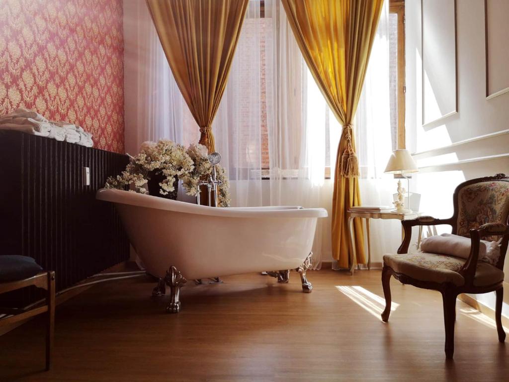 a bath tub in a room with a window at Love Nest Versailles - Unique Louis XIV decoration - Calm location right IN city center in Namur