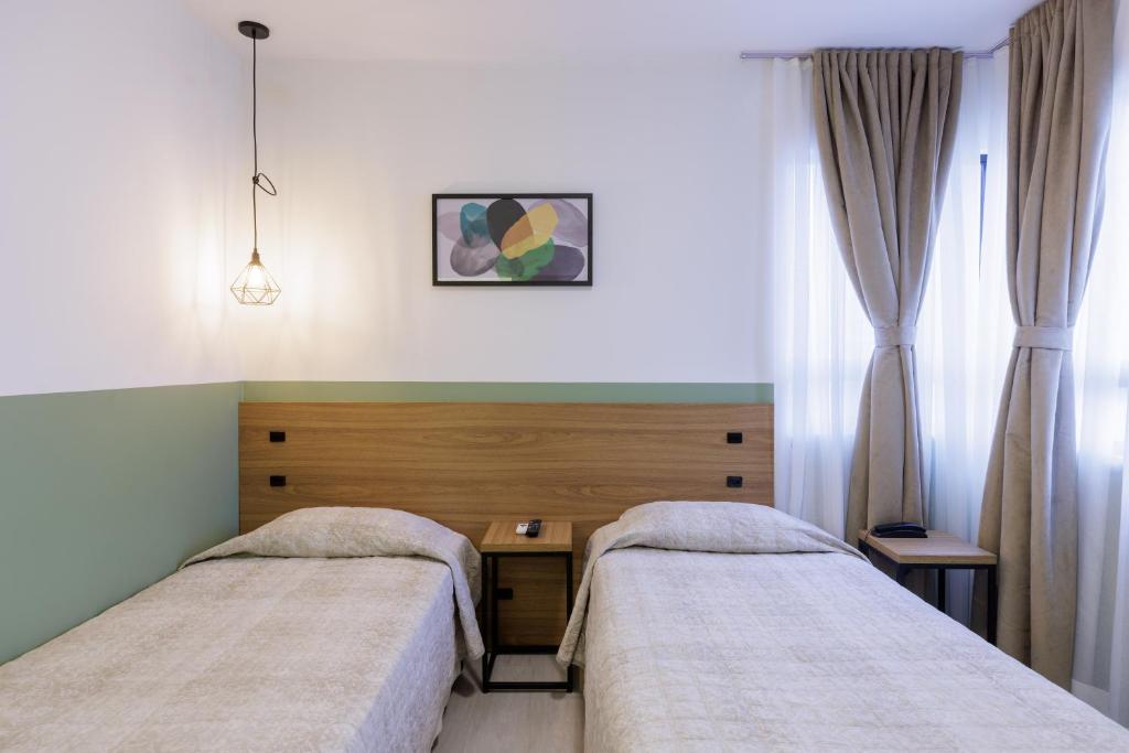 - une chambre à l'hôpital avec 2 lits et un bureau dans l'établissement Hotel Le Village Distributed By Intercity, à Joinville