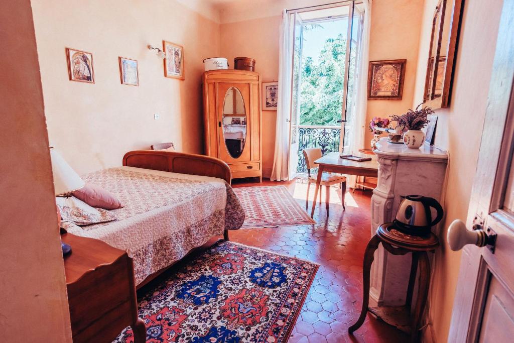 フォルカルキエにあるB&B en Provence- Villa Saint Marcのベッドルーム1室(ベッド2台、テーブル、窓付)