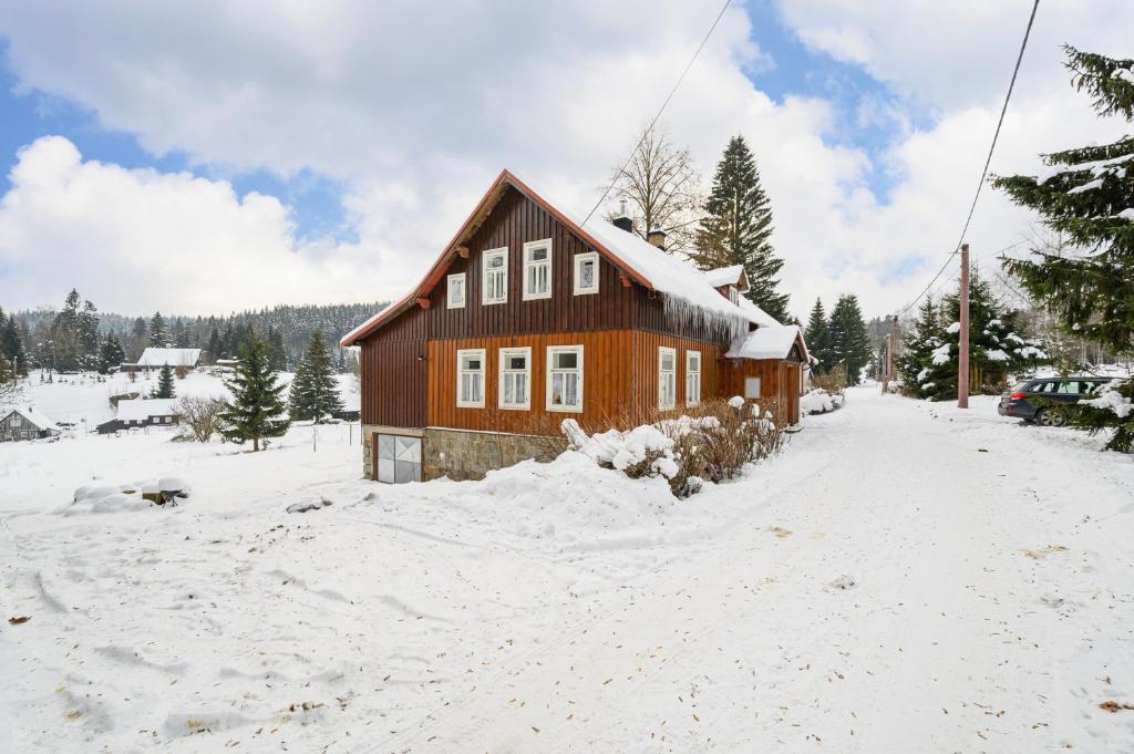 a wooden house in the snow with snow at Horská chalupa Horní Polubný in Kořenov