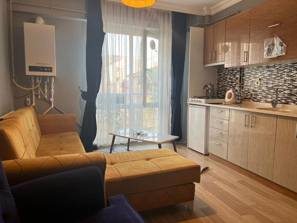 ein Wohnzimmer mit einem Sofa und einer Küche in der Unterkunft AYDOĞDU SUİT OTEL in Bolu