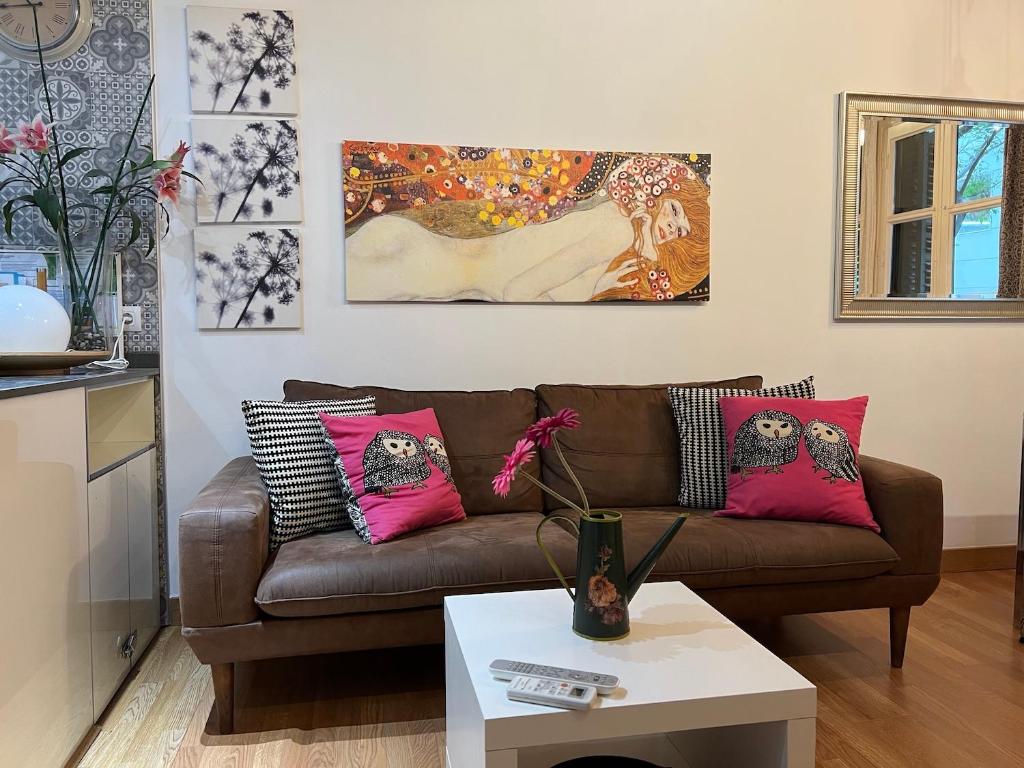 バルセロナにあるBlasco de Garay Apartment - Poble Secのリビングルーム(ピンクの枕と茶色のソファ付)