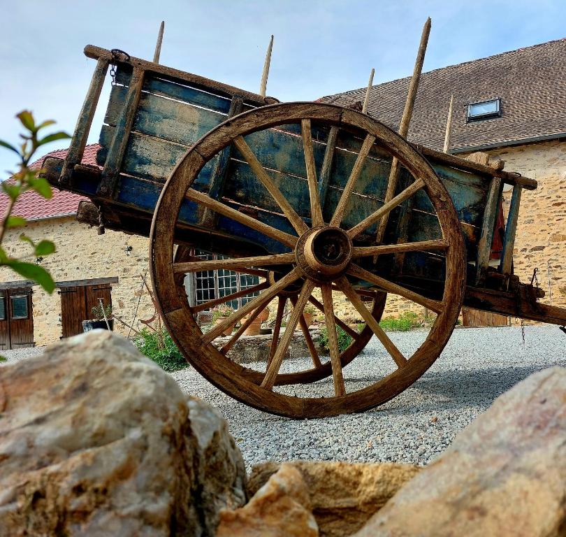 a wooden wagon sitting in front of a building at Chambre ďhôtes B&B le Figuier in Benayes