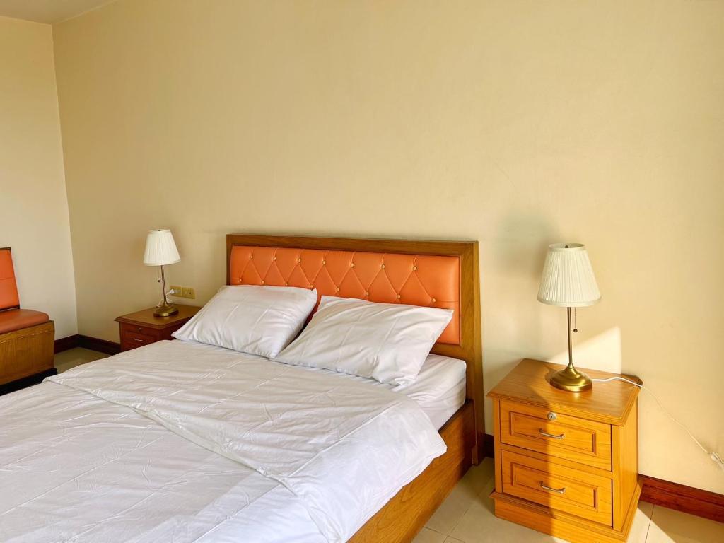 a bedroom with a bed and two night stands with lamps at THE POPULAR PLACE in Ban Khlong Thewa