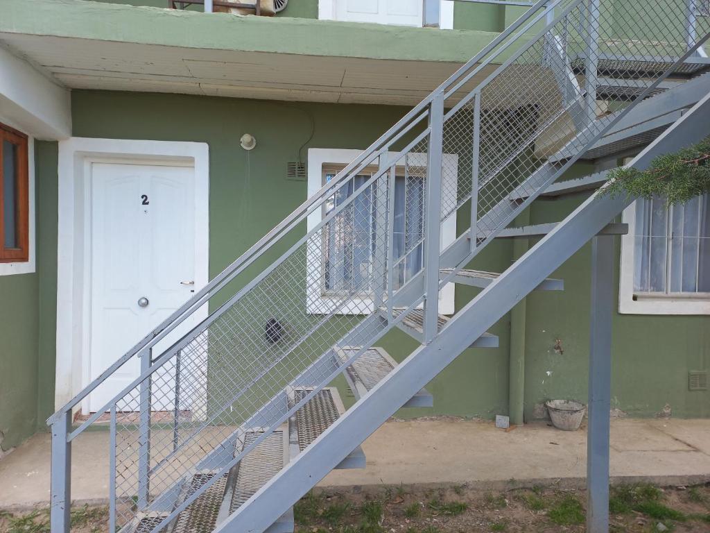 Una escalera de metal que conduce a una casa con puerta en Las cuatro Hermanas1 en El Calafate
