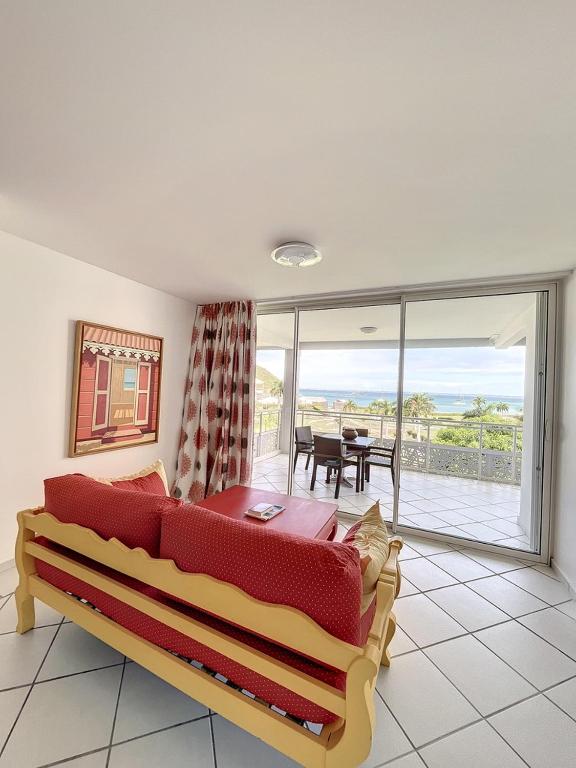 a living room with a couch and a view of the ocean at Le Domaine Anse Marcel Beach Resort in Anse Marcel 