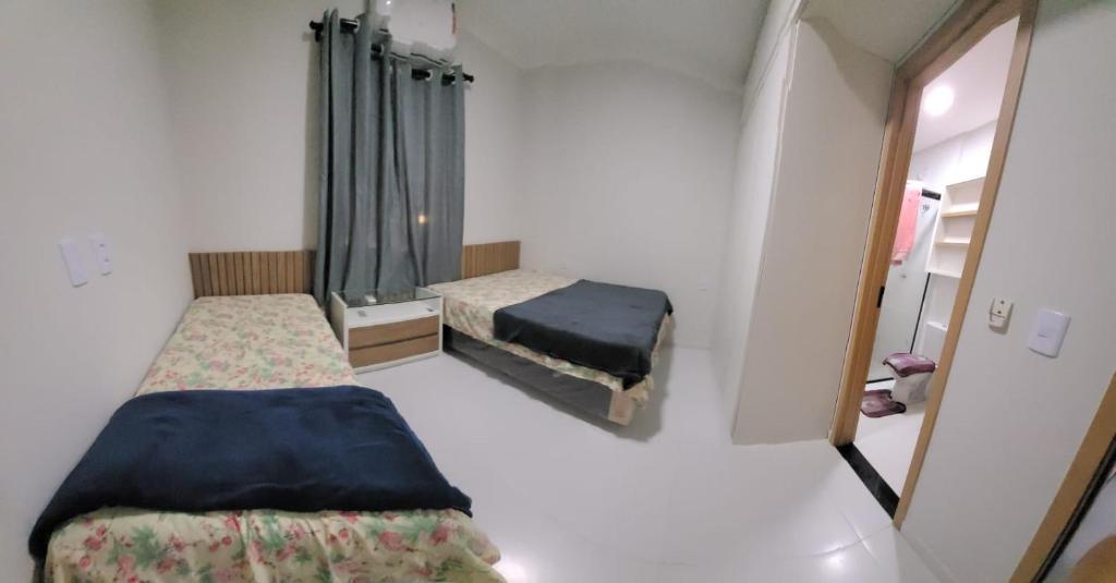 バヘイリーニャスにあるApartamento Condomínio Lençóis Confortの小さな部屋で、ベッド2台、鏡が備わります。
