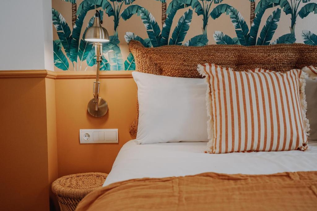 a bedroom with a bed with orange walls and a tropical wallpaper at Casa Los Yayos by Nomad Stays in Altea