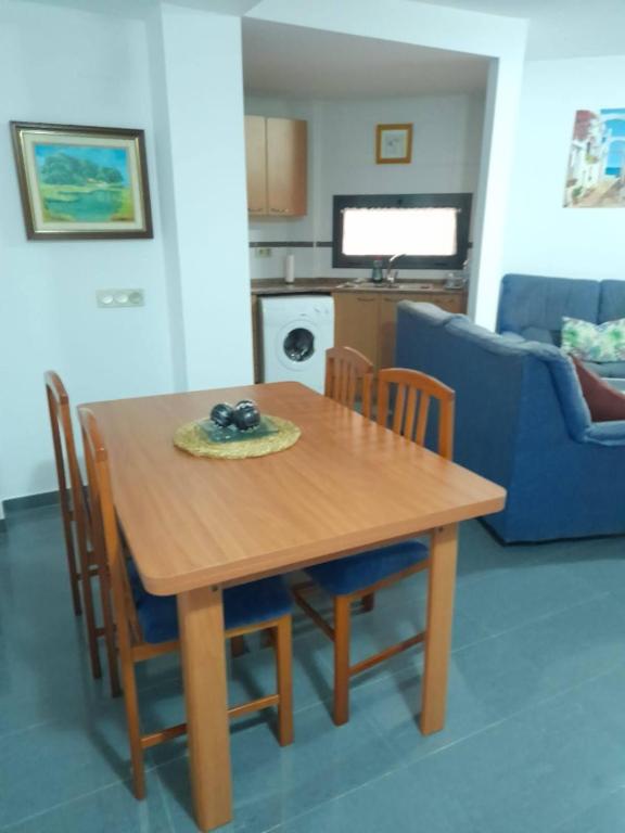 a wooden table and chairs in a living room at Deltebre Riu in Deltebre