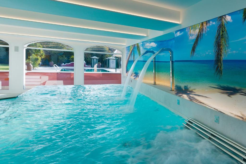 a indoor swimming pool with a water slide at Vip's Motel Luxury Accommodation & Spa in Lonato del Garda