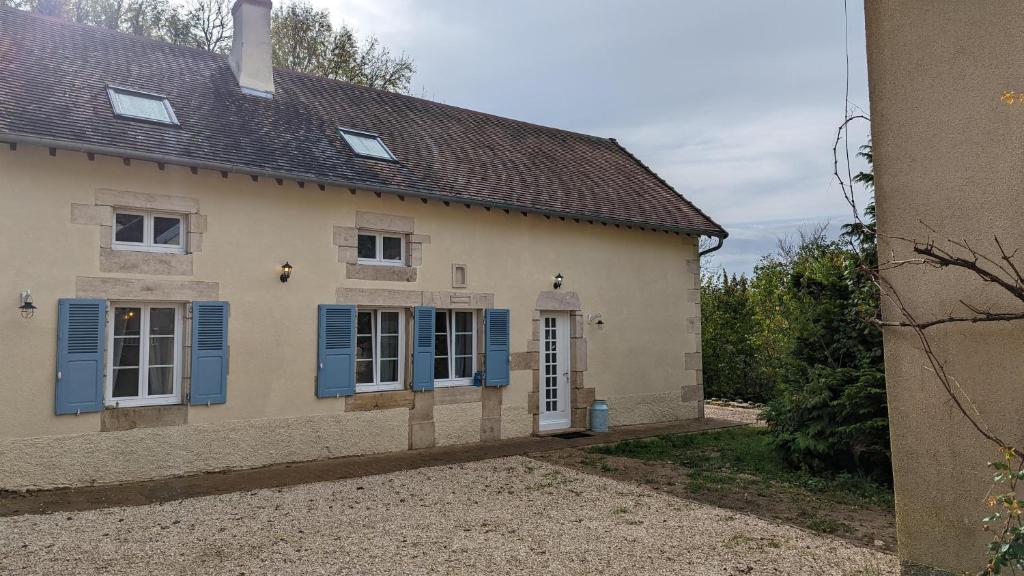 Una casa vieja con persianas azules. en La Belle Noue, en Bellenod-sur-Seine