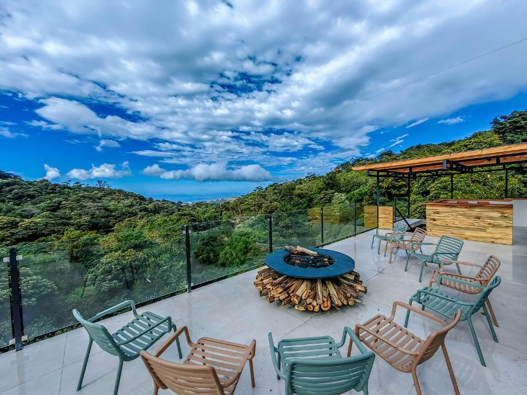 a patio with chairs and a table with a view at Cloud Forest Lodge by Böëna in Monteverde Costa Rica