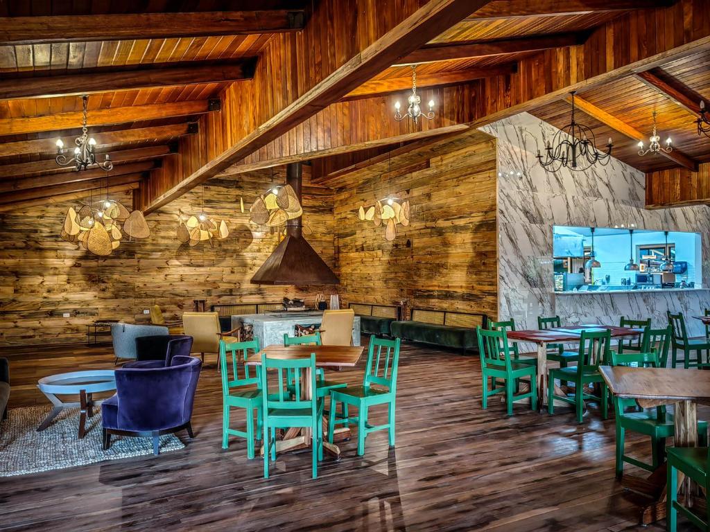 Un restaurante con paredes de madera y mesas y sillas. en Cloud Forest Lodge, en Monteverde