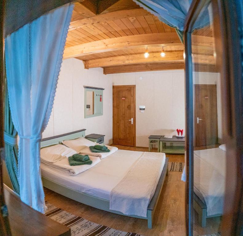 a bedroom with a bed with a blue canopy at Pensiunea Vanatorul in Băile Tuşnad