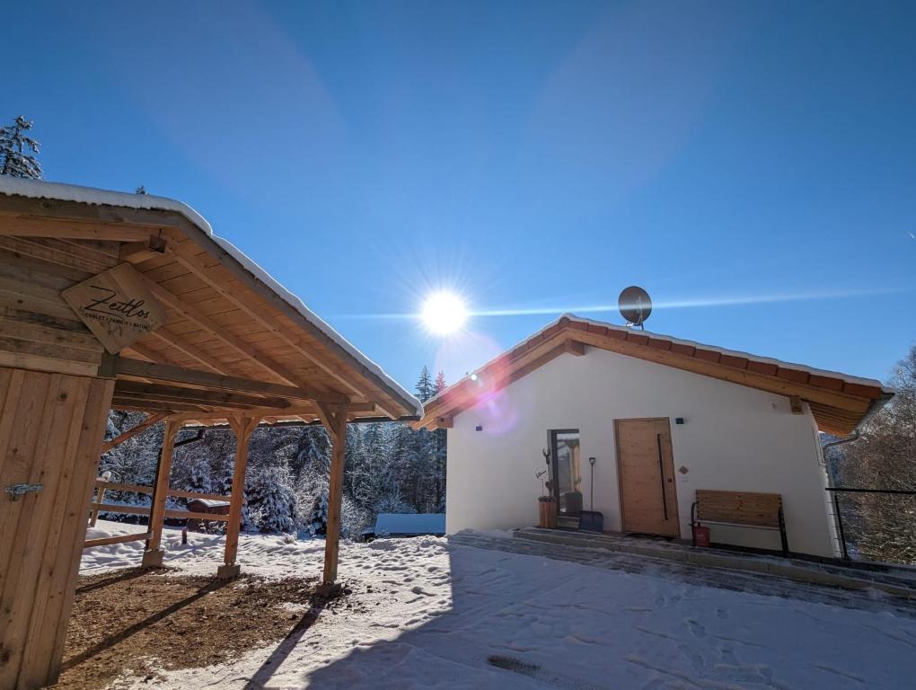 a house with a wooden roof in the snow at Zeitlos in Bodenmais