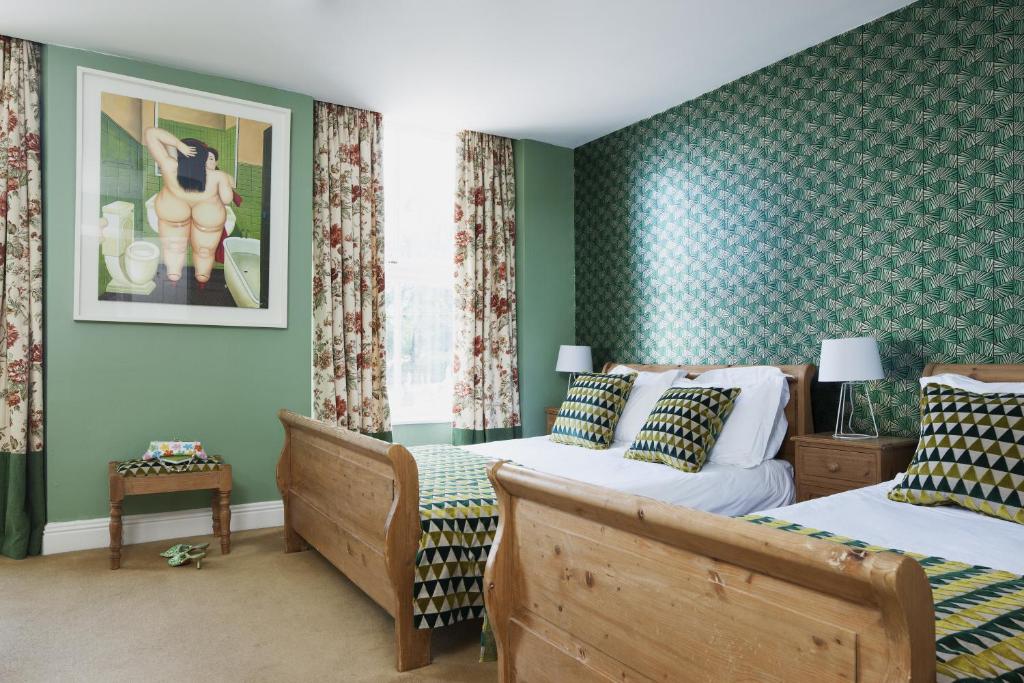 two beds in a room with green walls at The Townhouse Strand in Dunmore East