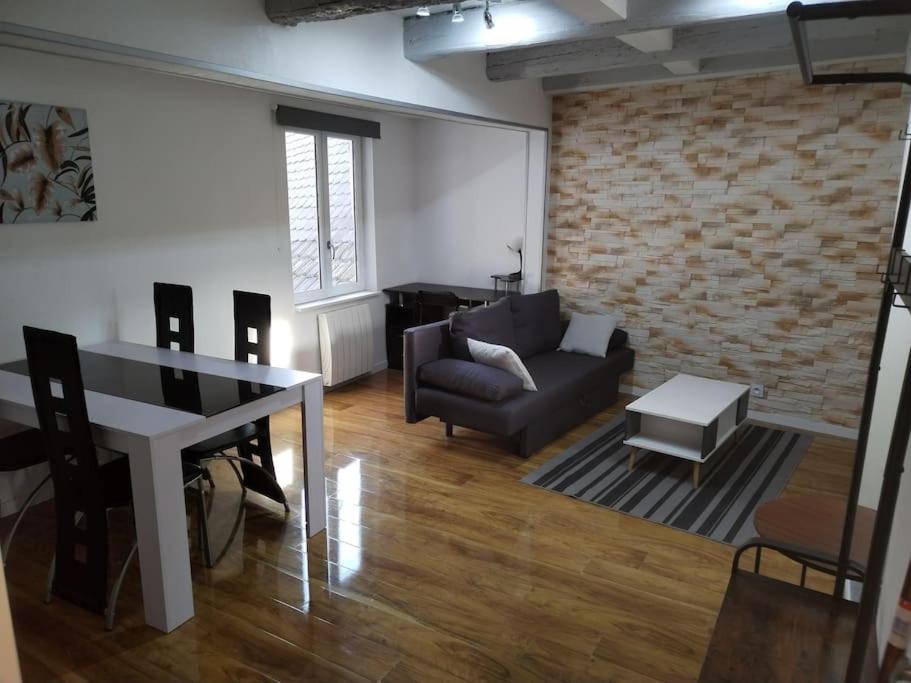- un salon avec un canapé et une table dans l'établissement Charmant appartement cosy, à Sélestat