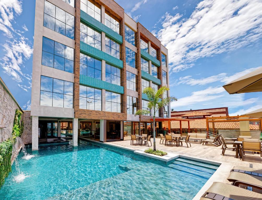 uma vista exterior de um edifício com piscina em Gaeta Hotel em Guarapari