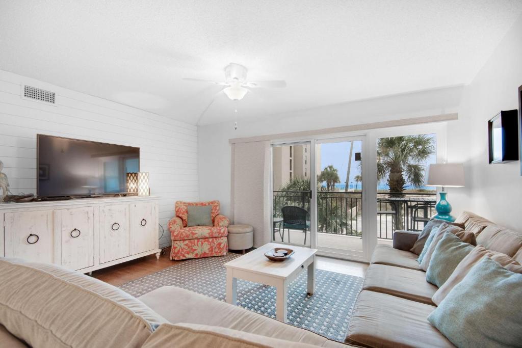 Una sala de estar con un sofá y un televisor. en Emerald Isle 208, en Fort Walton Beach