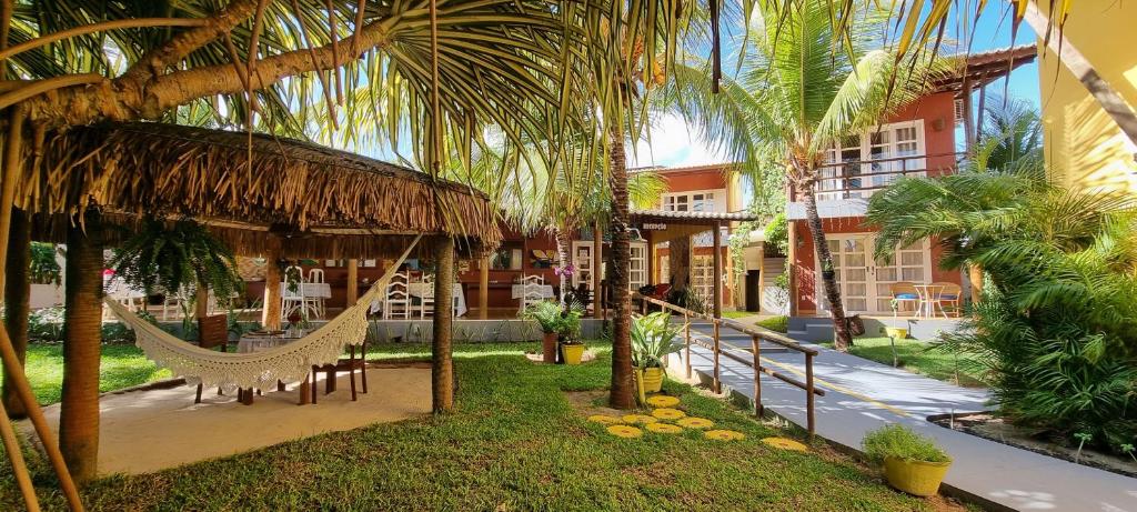 a hammock in the courtyard of a resort at Pousada Enseada do Gostoso in São Miguel do Gostoso