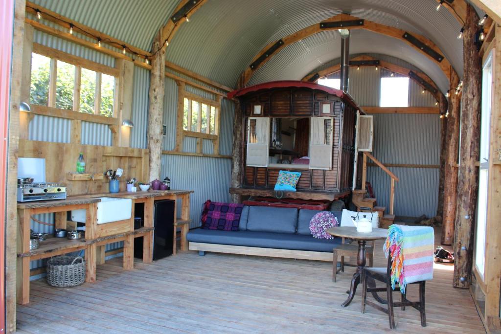 a living room with a blue couch and a table at The Edwardian Caravan 'Dora' in Lampeter
