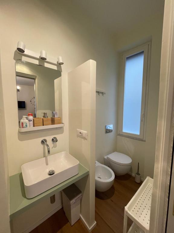 La salle de bains est pourvue d'un lavabo et de toilettes. dans l'établissement Palazzo Penco Apartment, à Gênes