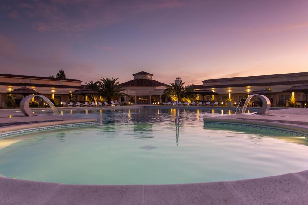 una gran piscina frente a un edificio por la noche en Melincue Casino & Resort en Melincué