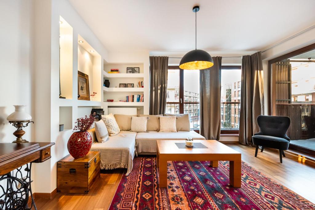 ein Wohnzimmer mit einem Sofa und einem Tisch in der Unterkunft Bemowo Green Wood Apartment in Warschau