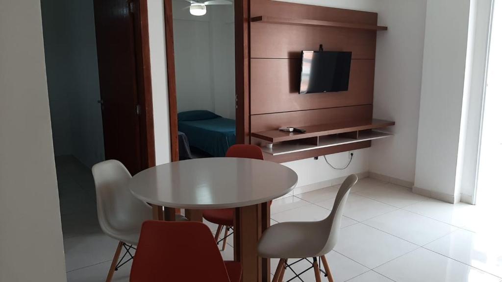 a room with a table and chairs and a tv at Jockey Family Chamonix 2 in Vila Velha