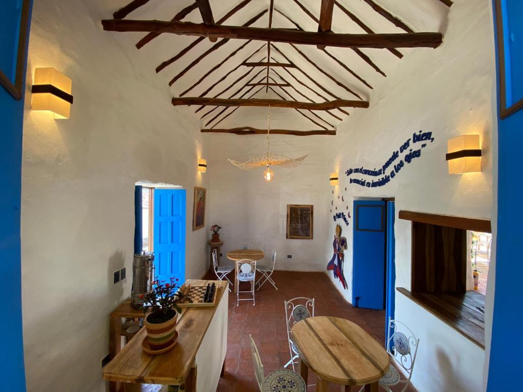 sala de estar con mesa y puertas azules en El Principito Hospedaje, en Barichara