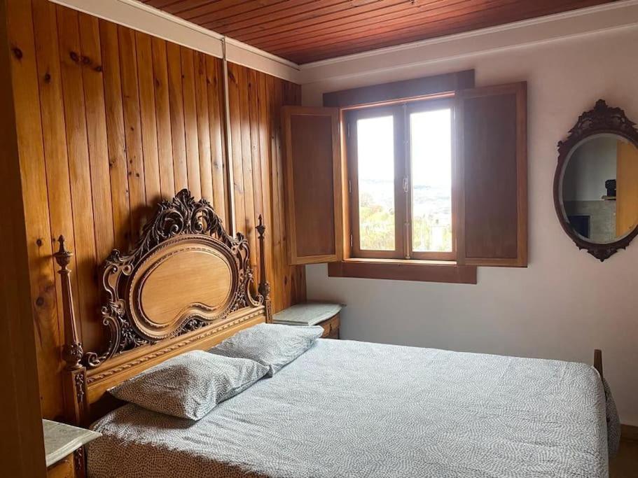 een slaapkamer met een bed met een spiegel en een raam bij casa da alegria in Urgueira