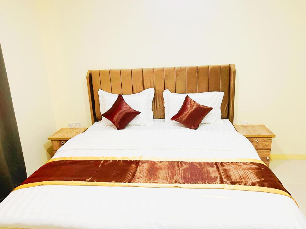 un grande letto con lenzuola e cuscini marroni e bianchi di دريم العليا للوحدات السكنية a Al Khobar
